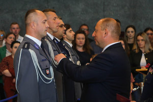 wojewoda gratuluje medalu policjantowi