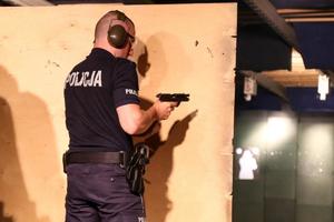 Policjant zmienia magazynek w pistolecie w trakcie strzelania