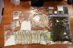 Zabezpieczone narkotyki pieniądze oraz wagi leżace na stole
