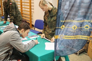 Podpisujący deklaracje maturzysta przy stoisku WCR