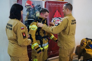 Strażacy ubierający w sprzęt ratowniczy maturzyste