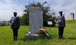 Obelisk na terenie Płaszowa i dwóch policjantów pełniących wartę honorową