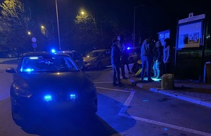 nieumundurowani policjanci wraz zatrzymanym mężczyzną który ma założone kajdanki na ręce trzymane z tyłu