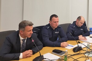 przedstawiciele Policji wraz z wójtemsiedzący przy biurku na debacie