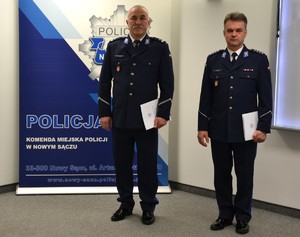 awansowani policjanci stoją przy banerze sądeckiej Policji — awatar