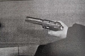 mężczyzna trzyma pistolet w dłoni