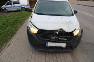 samochód z uszkodzoną karoserią  w tle radiowóz