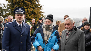 Od lewej stoją umundurowany policjant, mężczyzna w czapce, prezydent miasta krakowa