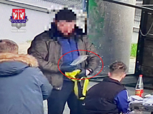 policjant kryminalny sprawdzający zawartość plecaka młodego mężczyzny