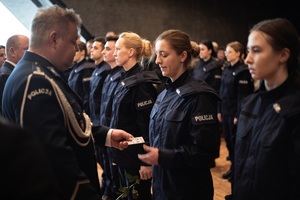 Komendant Wojewódzki Policji wręczający policjantce legitymację.