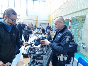 Policjant ruchu drogowego prezentuje sprzęt i wyposażenie wykorzystywane w służbie