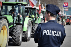 umundurowany policjant, w tle ciągniki rolnicze