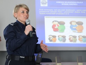 Policjantka w mundurze z mikrofonem w ręce