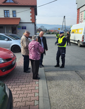 Dyrektor MORD przekazuje seniorom odblaski, obok policjant