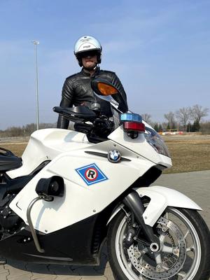 Policjant ruchu drogowego stoi przy motocyklu policyjnym