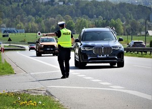 umundurowany policjant zatrzymujący samochód osobowy do kontroli