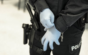 policjant zakłada rękawiczki lateksowe