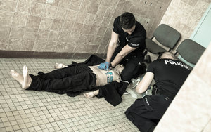 dwoje policjantów udziela pomocy pracując na manekinie - trwa resuscytacja