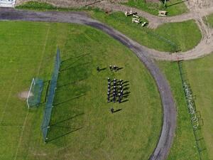 Pododdział policji ćwiczy przemarsz na płycie boiska