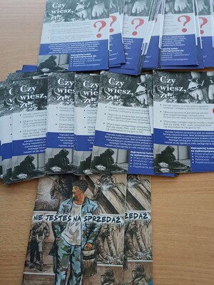 Ulotki  na temat handlu ludźmi poukładane na stoliku