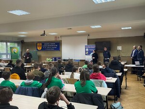 zawodnicy siedzą przy stolikach w sali