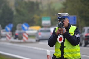 Policjant ruchu drogowego mierzy prędkość pojazdów przy użyciu ręcznego miernika prędkości