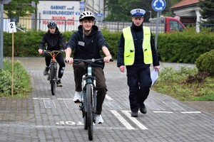 policjant oraz uczestnik turnieju na miasteczku ruchu drogowego