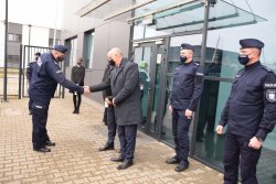 Komendant Powiatowy Policji w Krakowie poprzez podanie ręki dziękuje samorządowcom za przekazane radiowozy