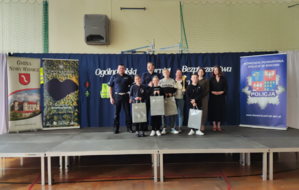 Organizatorzy turnieju, umundurowani policjanci oraz uczestnicy turnieju z nagrodami