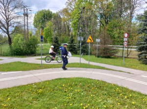 Umundurowany policjant oraz osoba biorąca udział w turnieju podczas testu praktycznego