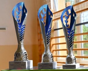 puchary w tle drabinki do ćwiczeń na sali gimnastycznej