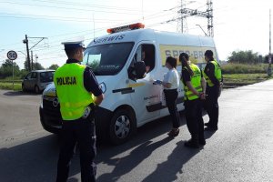 Akcja Bezpieczny Przejazd funkcjonariusze wręczają materiały profilaktycze kierowcy dostawczaka