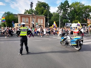 Policjant ruchu drogowego, motocykl policyjny i uczestnicy marszu