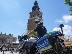 policjant na motorze w tle wieża ratuszowa