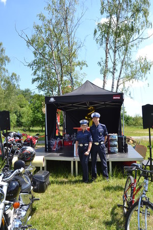 Policjantka i policjant stoją przy scenie podczas spotkania motocyklistów