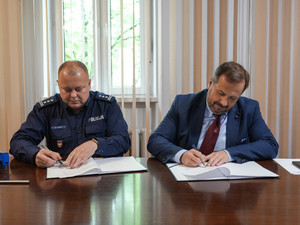 insp. Mariusz Kudela oraz dr. hab. n. med. Bartłomiej Guzik podpisują porozumienie.