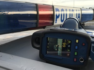 Ręczny miernik prędkości ułożony na dachu radiowozu policyjnego