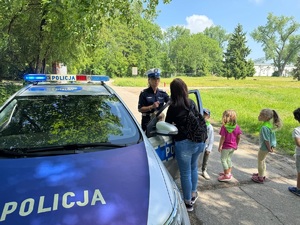 policjantka pokazująca dzieciom radiowóz