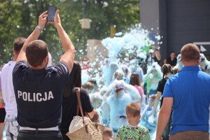policjant robi zdjęcie dzieciom w piana party