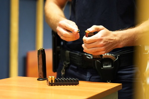 policjant ładuje magazynek pistoletu