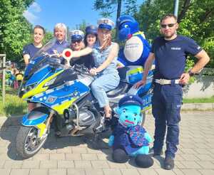 pamiątkowa fotoghrafia policjanów oraz uczestników przy motocyklu policyjnym