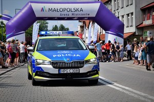 policyjny oznakowany radiowóz podczas zabezpieczenia wyścigu kolarskiego