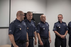 Czterech umundurowanych policjantów w sali wykładowej