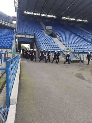 umundurowani policjaci wbiegający przez tunel na stadion piłkarski przy ulicy Reymonta