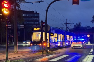 tramwaj na jednej z krakowskich ulic, obok którego znajduje się pojazd krakowskiego mpk. Na zdjęciu widać też część policyjnego radiowozu
