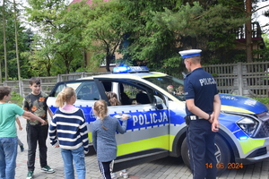 Dzieci z policjnatem przed radiowozem