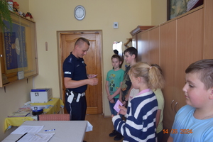 Dzieci z policjantem w gabinecie szkolnym