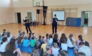 Policjantki na sali gimnastycznej podczas prelekcji z uczniami