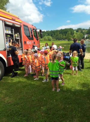 Przedszkolaki oglądające wóz strażacki i znajdujący się na wyposażeniu sprzęt