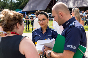 Policjanci rozmawiaja z uczestniczką pikniku